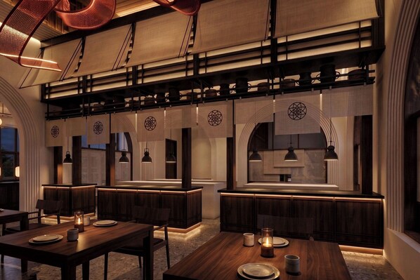 L’intérieur d’un restaurant, avec des tables et des chaises en bois, et un comptoir central.