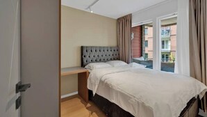 Ein Schlafzimmer mit einem Bett, einem Nachttisch und einem Fenster mit Vorhängen.