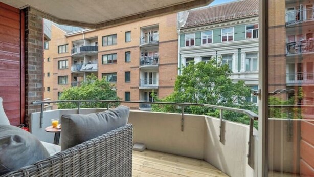 Ein Balkon mit Korbmöbeln und Blick auf die Nachbargebäude.