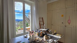 Une pièce avec une grande fenêtre, un établi et une armoire.