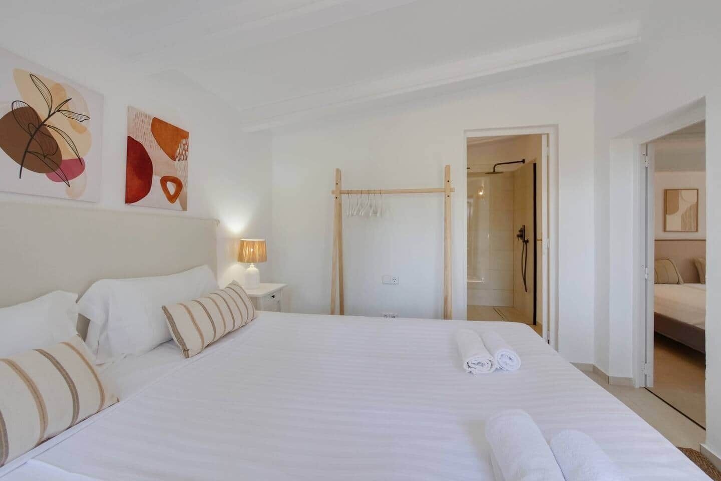 Une chambre d’hôtel avec un grand lit, une table de chevet avec une lampe et un espace douche.