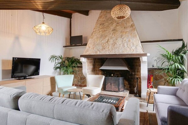 A living room with a stone fireplace, a television, and seating arrangements. - Caragol 2 - Nature, XXL Pool, Yoga, AC (AG/6) (Manacor)
