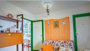A room with a bed, a chair, a shelf with items, and a door. - Comfortable house with terrace a stone's throw from the sea in mild climate location (Villapiana Lido)