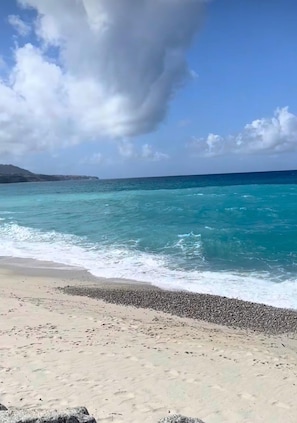 A beach with clear turquoise waters, a pebbly shore, and a distant mountain range under a partly cloudy sky. - A comfortable house with a terrace, just a stone's throw from the sea in a mild climate (Villapiana Lido)