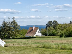 A house with a sloped roof, surrounded by greenery and a view of the sea. - "Kirsti" - 300m from the sea by Interhome (Allinge)