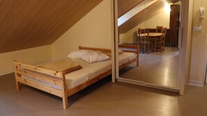 A small, wooden-framed room with a loft bed and a dining table with chairs. - chalet-style apartment, 5 minutes from the ski slopes (Les Rousses)