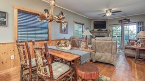 A dining area with a wooden table, chairs, and a chandelier. - 2BR Village At Indian Point 501 near SDC-Free Tickets Daily up to $500 (Branson)