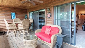 A wooden deck with wicker furniture, a glass door leading to a room, and a ceiling fan. - 2BR Village At Indian Point 0611 near SDC-Free Tickets Daily up to $500 Value (Branson)