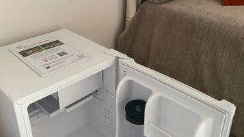 A compact refrigerator with a control panel, a small drawer, and a freezer compartment.