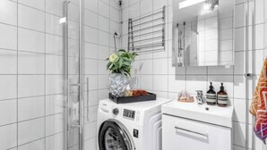 A modern bathroom with a washing machine, a sink, and a mirror. - Modern apartment in the heart of Oslo with balcony (Oslo)