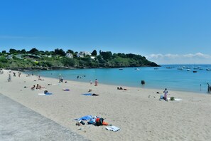 A beach with people, boats, and houses in the background. - Maison les flots de port-mer, 2 min walk to Port Mer beach (Cancale)
