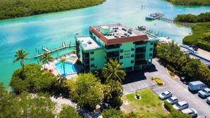Un resort con piscina, muelle y vistas al agua y follaje circundantes.
