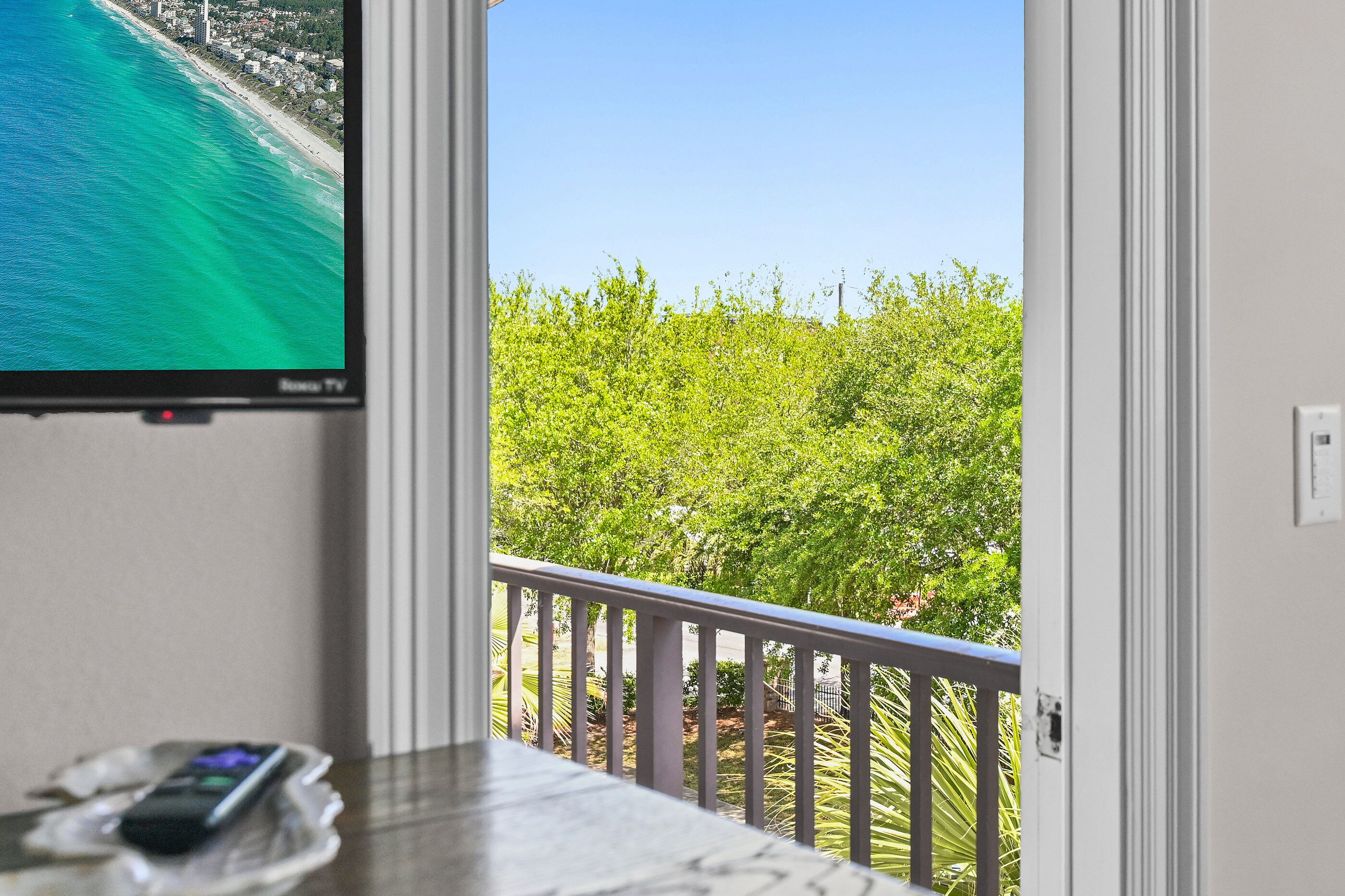 A balcony with a view of the ocean and greenery.