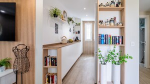 Una cocina moderna con armarios de madera, horno empotrado y encimera con un hervidor y un cuenco de fruta.