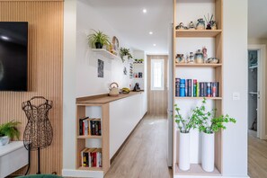 Eine moderne Küche mit Holzausbau, einem eingebauten Backofen und einer Arbeitsplatte mit Wasserkocher und Obstschale.