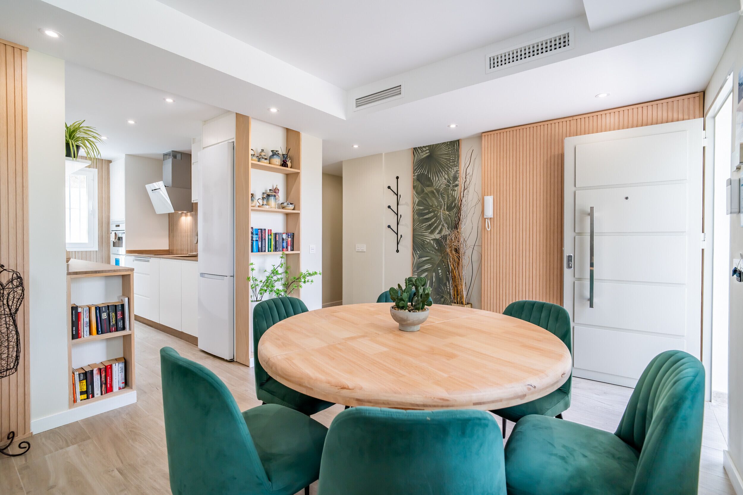 A modern kitchen with white cabinets, a built-in oven, and a white refrigerator.