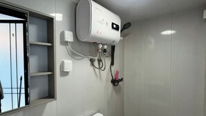 Un baño con inodoro, lavabo y aire acondicionado de pared.