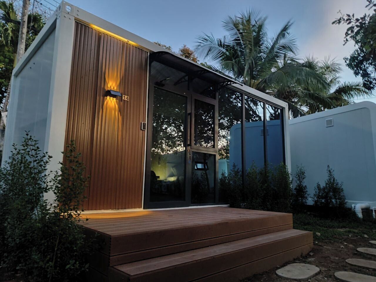 A modern building with a wooden facade, glass doors, and a wooden deck.