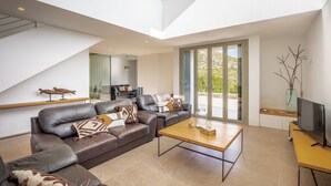 A modern living room with a sectional sofa, a coffee table, and a flat-screen TV. - Unique villa with swimming pool located in the mountains (Las Palmeras)