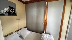 A bedroom with a bed, a painting on the wall, and a wooden headboard. - Les arcs 1800 - T2 827 - 5 pers parking/housekeeping included (Bourg-Saint-Maurice)