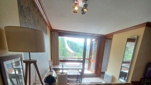 A room with a large window, a desk, a lamp, and a mirror. - Les arcs 1800 - T2 827 - 5 pers parking/housekeeping included (Bourg-Saint-Maurice)