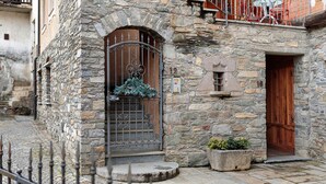 A stone building with a wooden door and a metal gate. - Casa Gardenia Apartment with Mountain View, Private Terrace and Wi-Fi (Rochefort)
