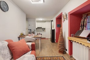 A compact living space with a kitchenette, a dining area, and a workspace.
