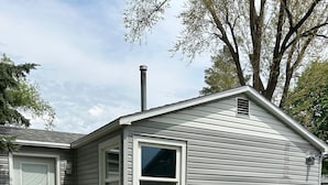 A single-story house with a front door, a window, and a chimney. - Adorable 1-bedroom bungalow with AC in Sergeant Bluff (Sergeant Bluff)