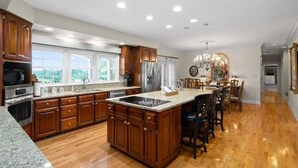 Una cocina amplia con armarios de madera, encimera de granito y una isla grande.