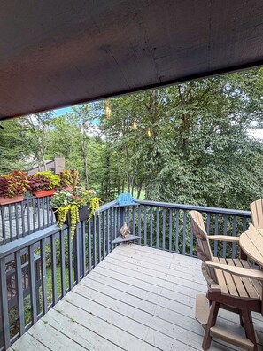 A wooden deck with a railing, outdoor furniture, and potted plants. - Golf, Mountain Air & Relaxation – Hideaway on the Green Awaits (Sugar Mountain)
