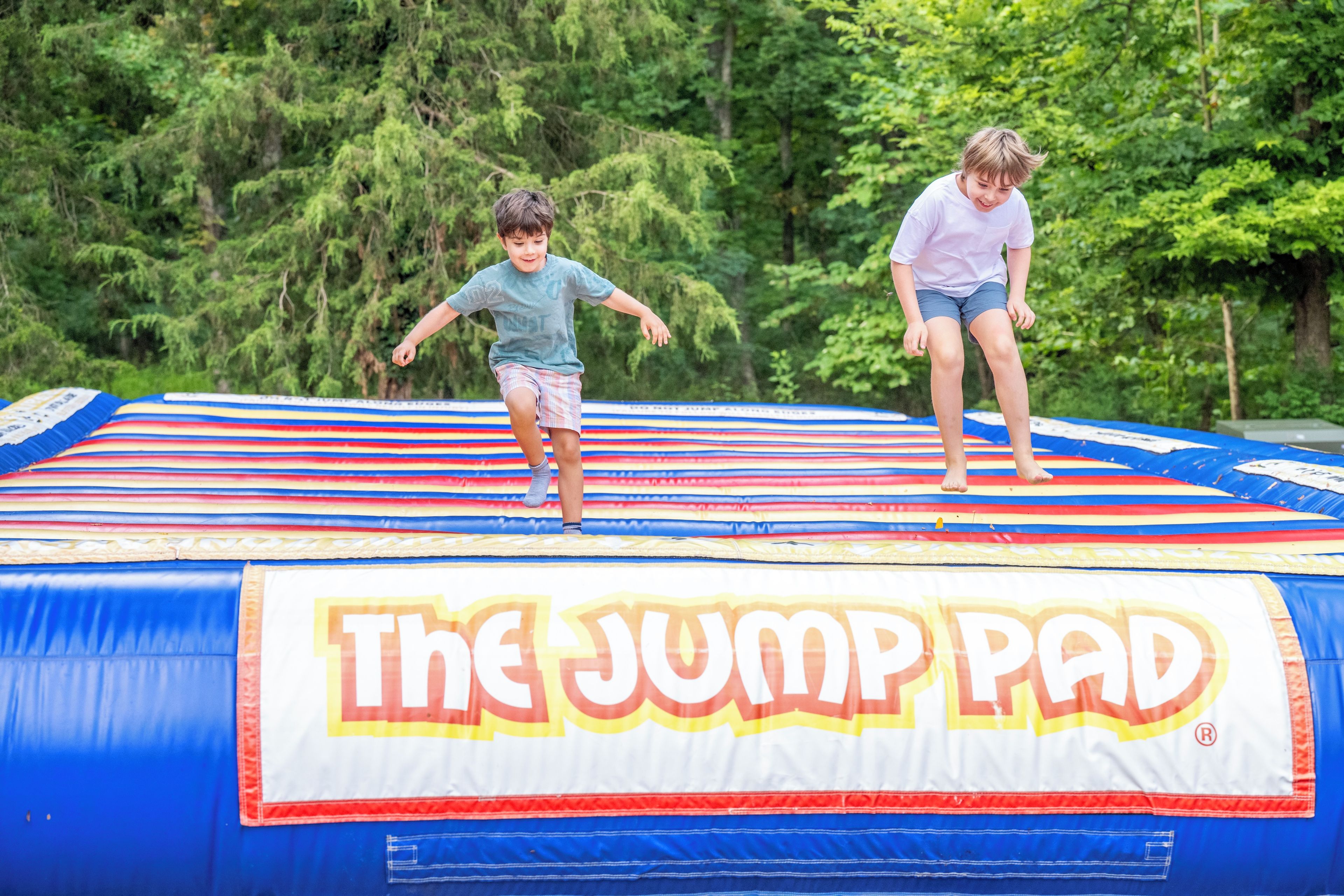 Two children jumping on a trampoline with a 'The Jump Pad' logo.
