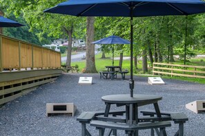A picnic area with tables and benches, surrounded by a wooden fence and trees. - Endless Caverns RV Resort & Cavern Tours (New Market)