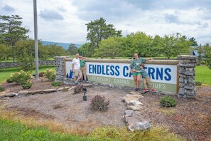 A sign for 'Endless Canyons RV Resort' with a stone wall and a grassy area with shrubs. - Endless Caverns RV Resort & Cavern Tours (New Market)
