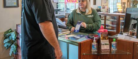 A reception desk with a computer, a guest pass, and a bottle of Purell sanitizer.