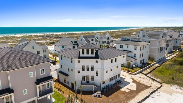 A coastal residential area with multi-story houses featuring gabled roofs and large windows. - Casamigos: Stunning Sugar Sands home w/ Private Pool, Sleeps 16, Pet-Friendly (Mecixo Beach)