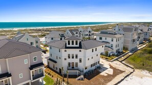 A coastal residential area with multi-story houses featuring gabled roofs and large windows. - Casamigos: Stunning Sugar Sands home w/ Private Pool, Sleeps 16, Pet-Friendly (Mecixo Beach)