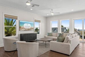 A spacious living room with a large flat-screen TV, comfortable seating, and a view of the beach. - Gulfstone: Gulf Front New Build, Private Pool, Pet Friendly, Sugar Sands Communi (Mexico Beach)