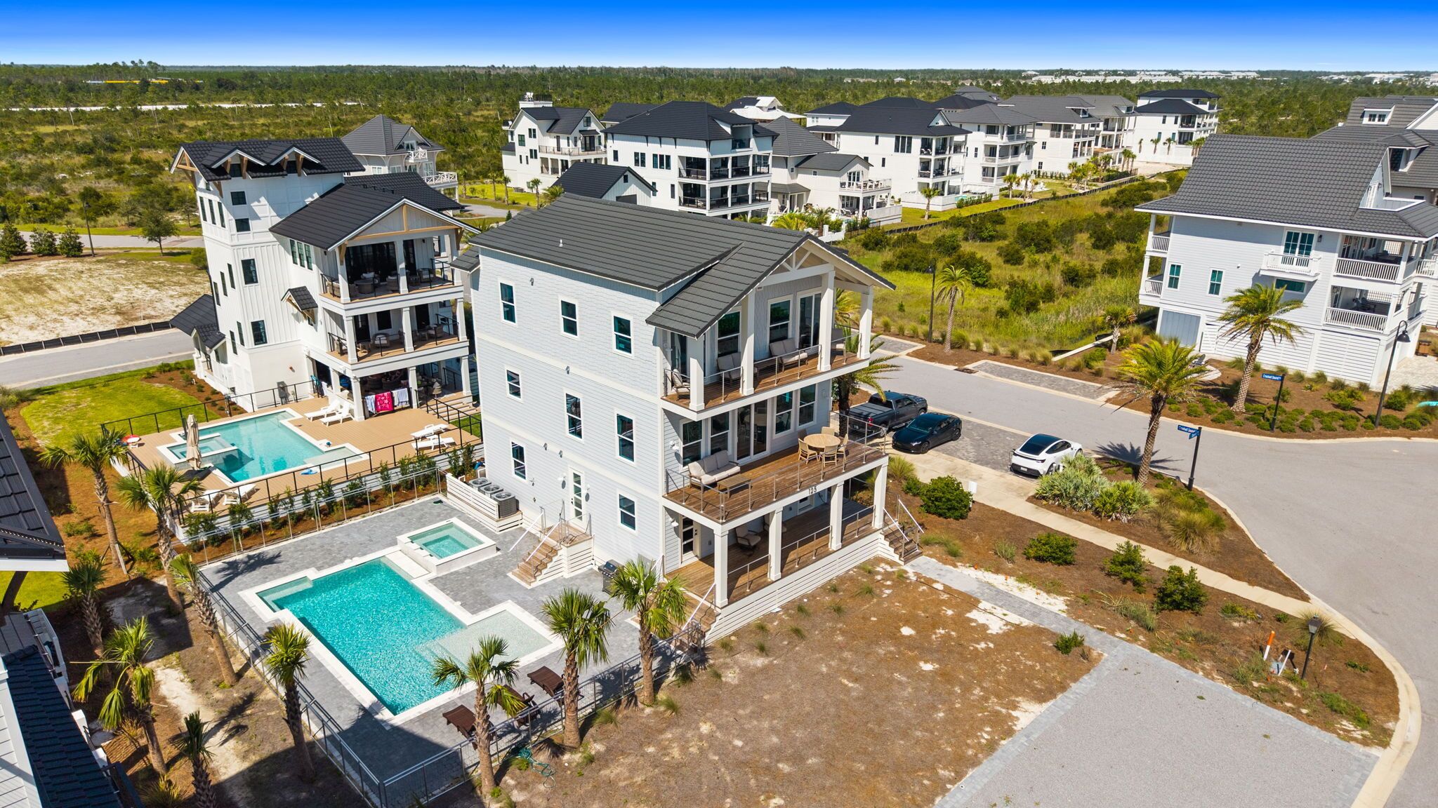 A multi-story residential building with a swimming pool, outdoor seating, and a well-maintained lawn.