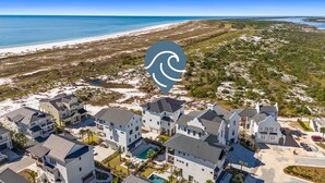 A coastal residential area with modern houses, a beach, and a clear view of the ocean. - Ocean Breeze: Unobstructed Views, Private Elevated Pool, Pet Friendly, Sleeps 19 (Mexico Beach)