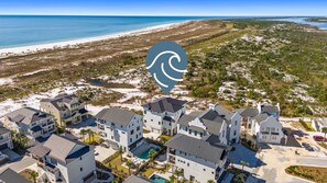 A coastal residential area with modern houses, a beach, and a clear view of the ocean. - Ocean Breeze: Unobstructed Views, Private Elevated Pool, Pet Friendly, Sleeps 19 (Mexico Beach)