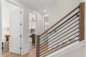 Una escalera con barandillas de madera y una pared blanca.