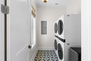 A laundry room with a door, a window, and a wall-mounted dryer. - New Build, Private Pool, Pet Friendly, Sugar Sands Community (Mexico Beach)