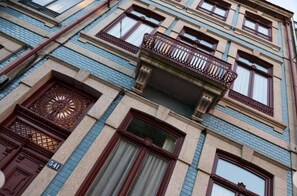 Un edificio de varios pisos con un balcón en el segundo piso.