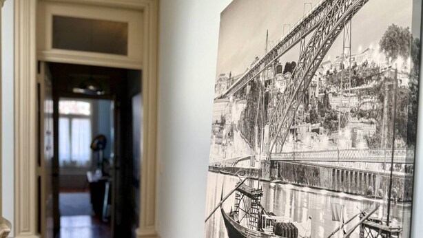 En hall med ett stort svartvitt fotografi som föreställer en bro och båtar på en flod.