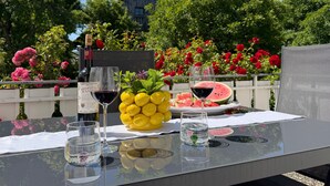 A table with a bottle of wine, glasses, lemons, and a watermelon. - Apartment Sieglinde with Private Terrace in Bad Dürrheim Öfingen (Bad Dürrheim)