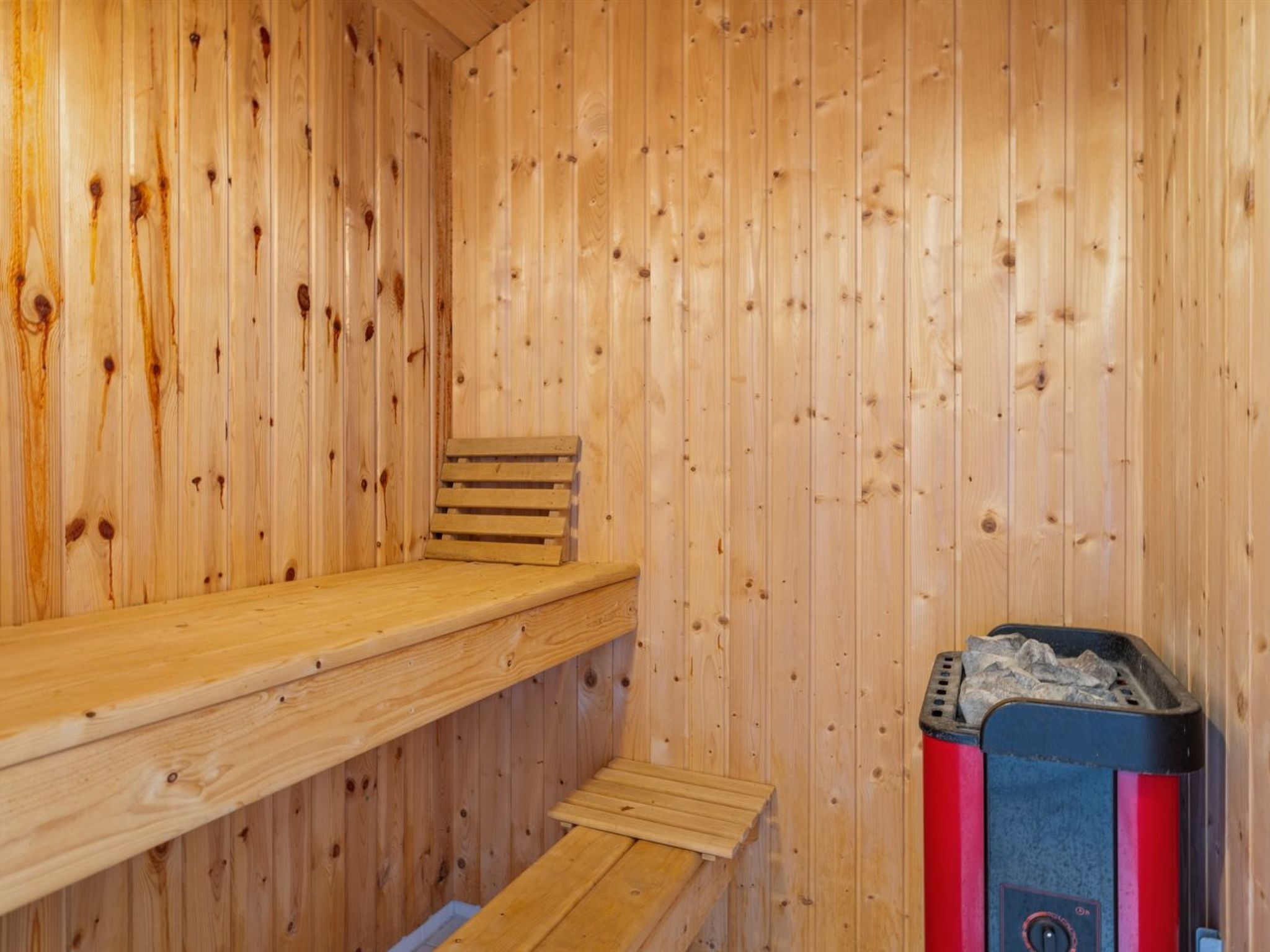 Eine Holzsauna mit Bänken und einer Saunaheizung.