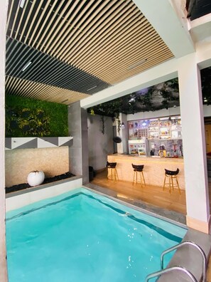 A modern indoor pool area with a bar and seating. - 2020 Apartment Guzape (Abuja)