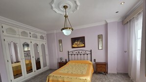 Ein Schlafzimmer mit Bett, Kleiderschrank und Deckenleuchte.