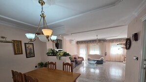 Ein geräumiges Wohnzimmer mit einem Holzessttisch, zwei Sofas und einer Deckenleuchte.
