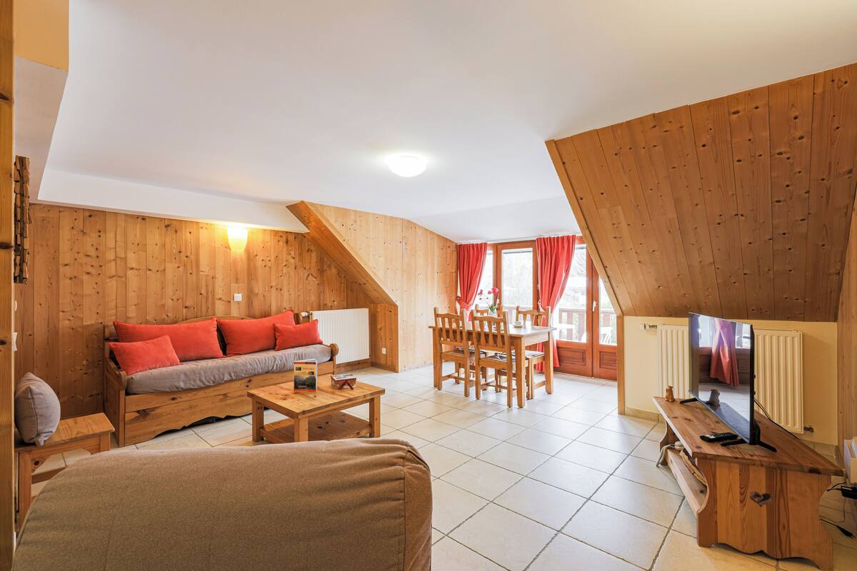 Un salón acogedor con muebles de madera, un sofá, una mesita de centro y un comedor.